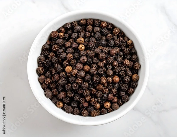 Fototapeta Black peppercorns in a white bowl on a marble surface