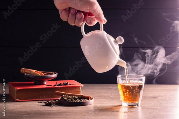 Fototapeta Hot tea is poured into glasses with steam. Teacups are placed on the table in the warm atmosphere of morning sunlight.