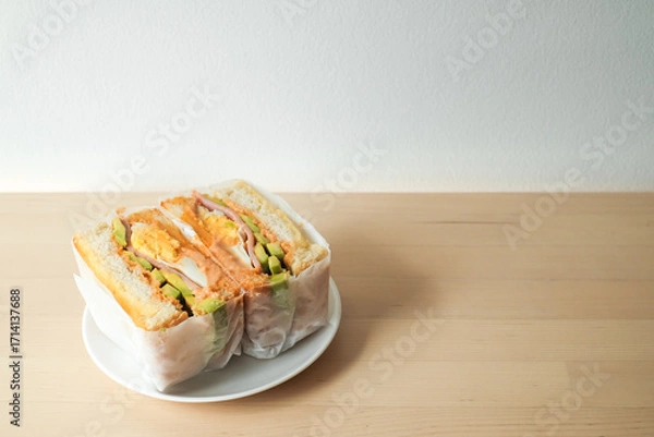 Fototapeta sandwich with filling in paper wrap in the morning.