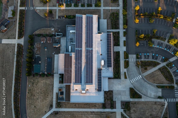 Fototapeta Aerial drone picture of a modern college building in Oregon City with rooftop solar panels, showcasing renewable energy technology and sustainable architecture in an academic campus setting