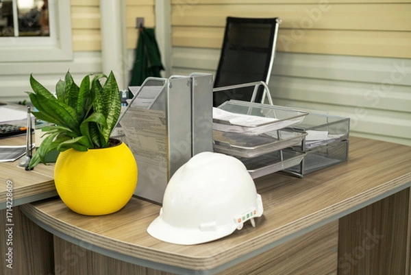 Fototapeta Civil construction engineer working at the desk office with white safety hard hat. Architecture project manager.