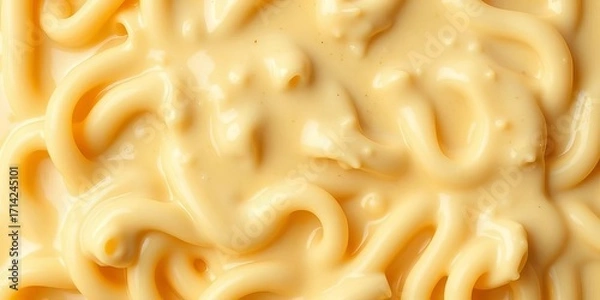 Fototapeta Creamy cheese sauce swirls over macaroni, forming an appetizing pattern,  cheesy,  overhead