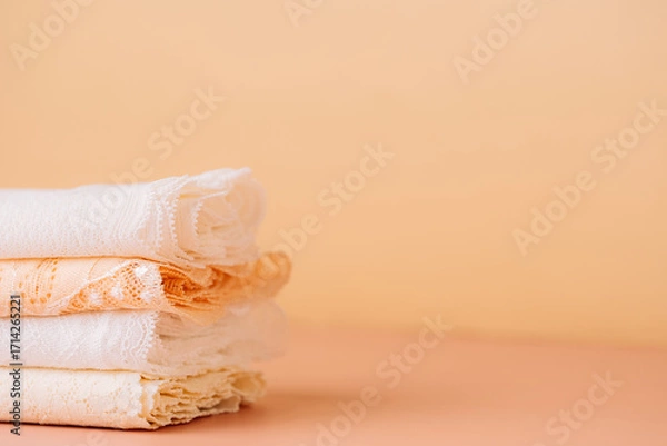 Fototapeta Small stack of white and peach lace, side view