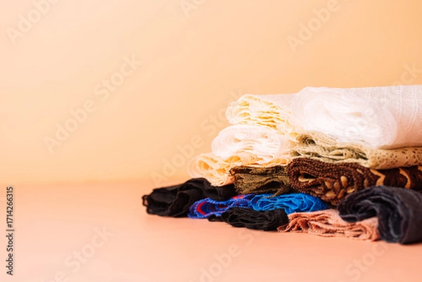 Fototapeta Pile of lace trims and fabrics on peach background, wide
