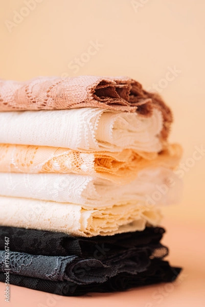 Fototapeta Stack of lace fabrics in pastel colors, vertical