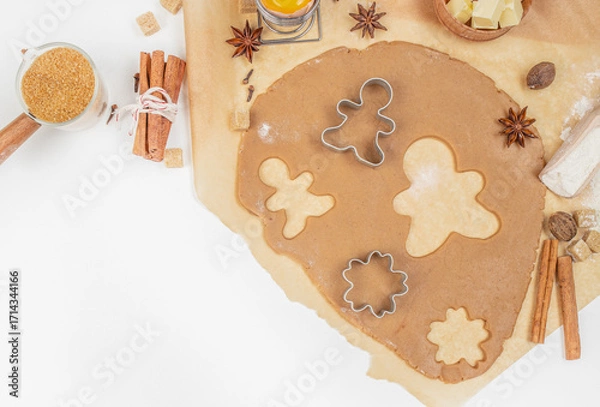 Fototapeta Gingerbread cookie dough with cutters, spices, and ingredients on kitchen table, top view, free space for text