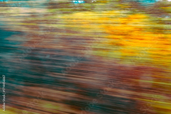 Fototapeta Dynamic motion blur view from high-speed train window: Green landscape, trees & fields rush past at high speed