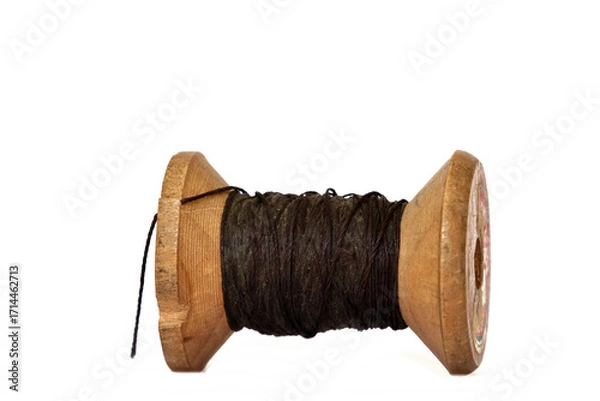 Fototapeta Old wooden bobbin of thread isolated on white