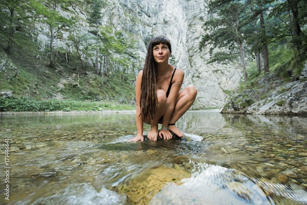 Fototapeta Beautiful hippie girl in an alpine river in Austria