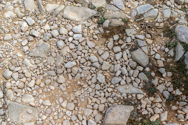 Fototapeta High angle view of ancient rocky hiking trail dirt path Via Algarviana smooth worn stones vegetation well used footpath