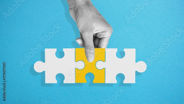 Fototapeta Completing a big job, the final of the project, the successful solution of business problems. The hand puts the last piece of the puzzle