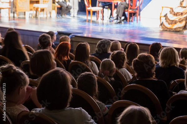 Fototapeta Publiczność w teatrze ogląda sztukę. Publiczność w sali: dorośli i dzieci.