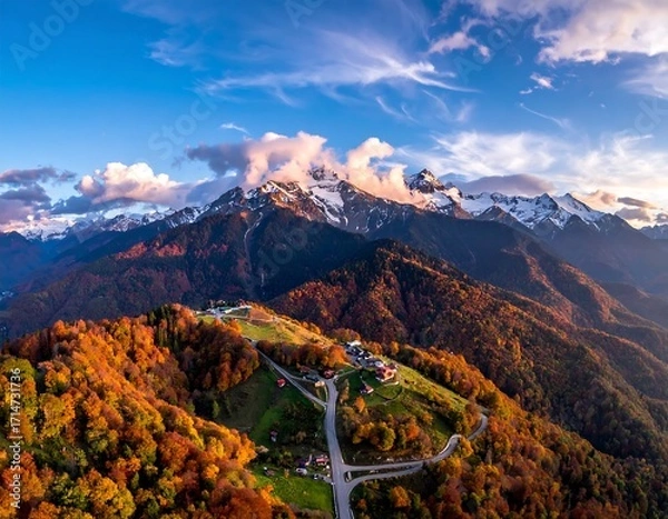 Fototapeta A breathtaking vista of autumnal mountains, showcasing vibrant foliage and snow-capped peaks under a dramatic sky.