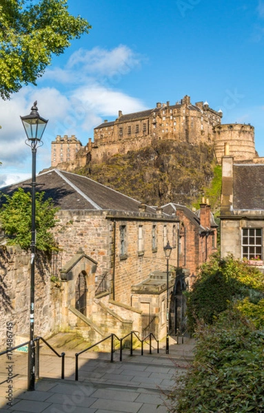 Fototapeta Edinburgh Castle on top of the rock taken from the Vennel off of Grassmarket, Edinburgh, Scotland, on a sunny summers day, showing the Victorian lamps lining the street