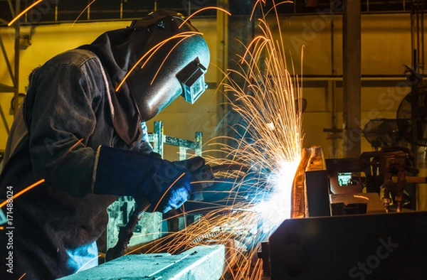 Obraz Worker, welding in a car factory with sparks, manufacturing, industry
