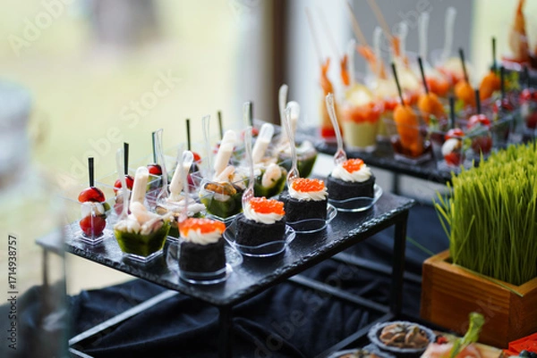 Obraz Canapés with caviar, vegetables and seafood in transparent mini-containers, wedding buffet.