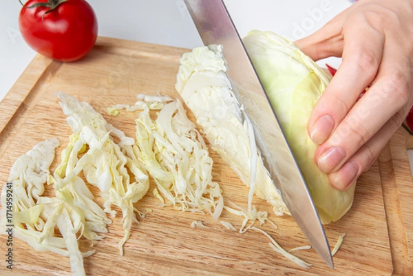 Fototapeta Chef Closeup Slicing White Cabbage On Wooden Cutting Board