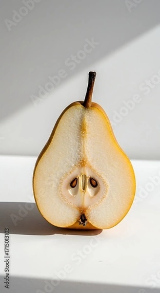 Fototapeta A halved pear with its seeds visible, isolated on white background