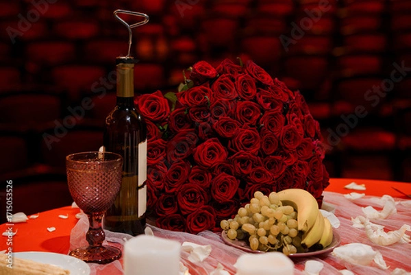Fototapeta Romantic Valentine's Day Setup: Red Roses, Wine, Grapes, and Glass on Table with Brick Wall Background
