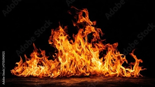 Fototapeta Bright orange and yellow flames surge upward, flickering dynamically against a black backdrop. The flames create a captivating and intense visual display, radiating warmth.