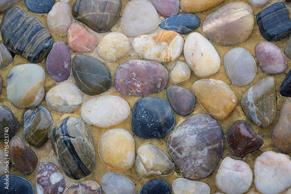 Fototapeta 2023-12-31 SEVERAL MULTI COLORED RIVER ROCKS SET IN PLASTER AS A BACKGROUND WITH NICE COLORING