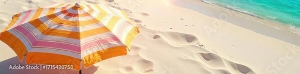 Fototapeta Vibrant striped beach umbrella casting shade on soft sand, creating a tranquil and inviting summer scene Perfect for travel, vacation, and summer holiday themes , shade, vacation