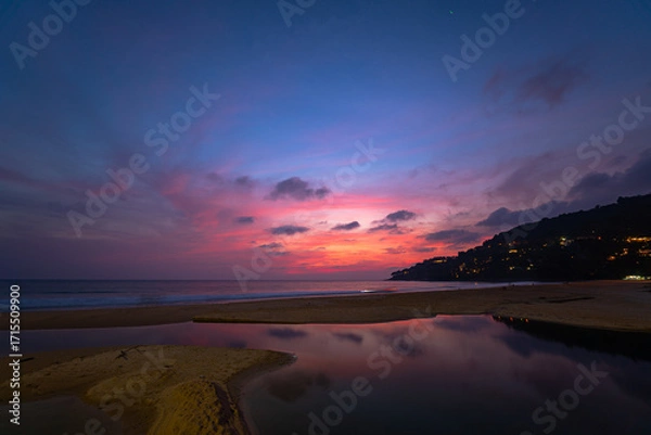 Fototapeta sweet sky at sunset reflection in the beach puddle. The sun's rays glistened in the puddle creating a mesmerizing dance of colors. stunning colorful reflection in sea surface.colorful sky