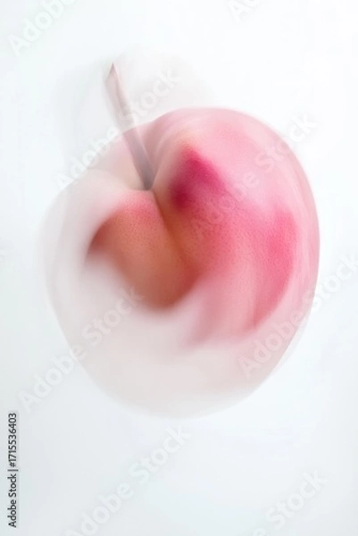 Obraz A pink fruit with a stem sits against a white background with a motion blur effect. AI.