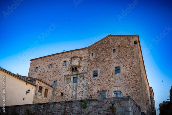 Fototapeta Vista panorámica del casco histórico de la ciudad española de Cáceres con vistas a los tejados de tejas marrones de edificios antiguos alrededor de la plaza principal en el soleado día de verano
