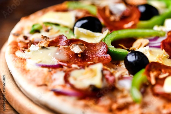 Fototapeta Pizza with chorizo ​​sausage, mozzarella cheese, green pepper and black olives. Rustic wooden background. Soft focus.	