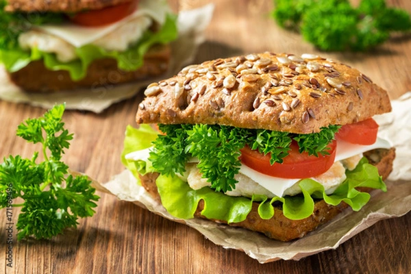 Fototapeta Homemade sandwich with chicken, fresh vegetables and herbs. Close-up.