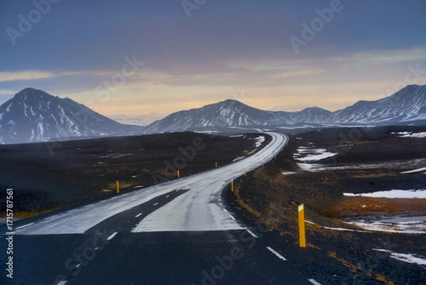 Fototapeta Road trip while travel after rainy time in Iceland with snow peak mountains view and colorful skyline.