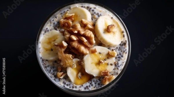 Fototapeta moody top view of overnight oats topped with bananas, walnuts, chia seeds, and drizzle of honey