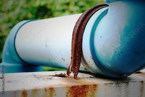 Obraz Rusted metallic joint on blue plastic pipe