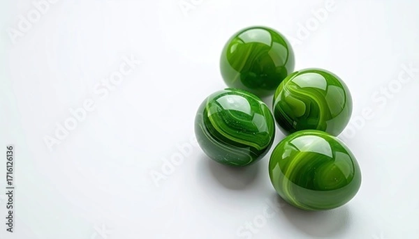 Fototapeta Four glossy green spheres with swirling internal patterns rest on a white background, arranged in a loose cluster