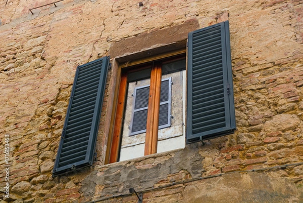 Obraz Old Stone Wall with Wooden Window and Shutters in Tuscany, Italy having reflection of a window on the glass