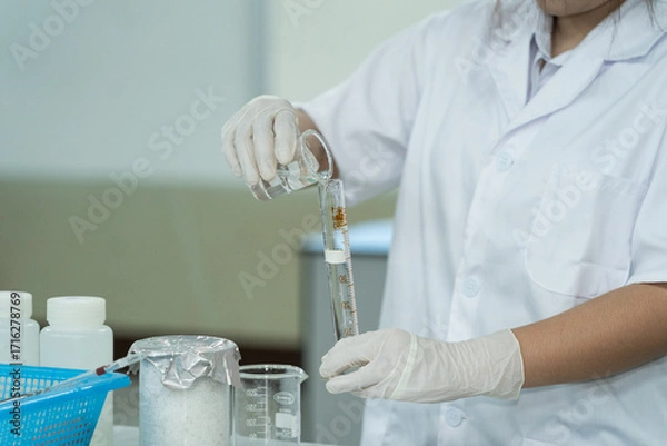 Fototapeta Medical Student Conducting Lab Experiment with Glassware
