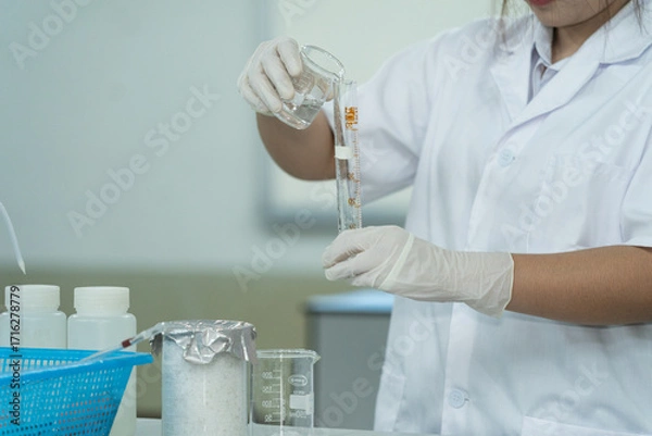 Fototapeta Medical Student Conducting Lab Experiment with Glassware