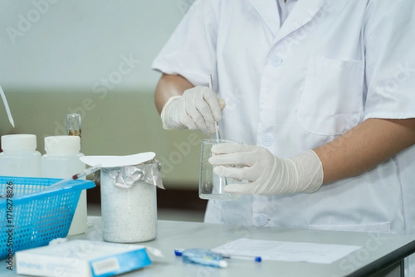 Fototapeta Medical Student Conducting Lab Experiment with Glassware