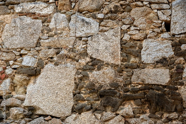 Fototapeta Fragment of a stone wall, built from rough stones of various sizes. For use as an abstract background and textures.
