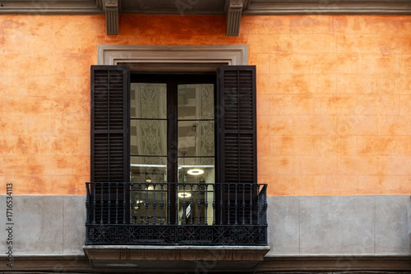 Fototapeta Rectangular window with balcony and dark brown shutters against wall of pink and gray tiles. From World Windows series.