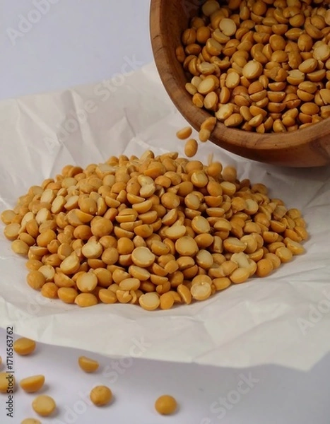 Fototapeta Dried yellow split peas spilling from a bowl