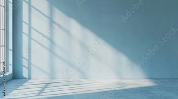 Fototapeta Sunlight streams through a window casting shadows on a blue wall and floor.