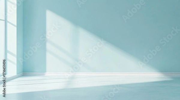 Fototapeta Light streams through a window onto a blue wall and floor.