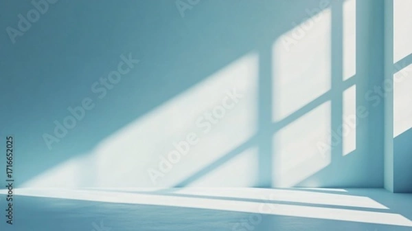 Fototapeta Sunlight streams through a window casting shadows on a blue wall and floor.