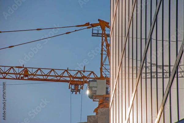 Obraz Crane Cabin and Glass Facade with Reflections in Late Afternoon Sunlight
