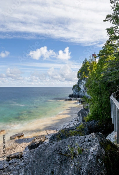 Obraz Flowerpot Island lighthouse offers stunning views of craggy cliffs, turquoise waters, and the serene Georgian Bay in Ontario, Canada.