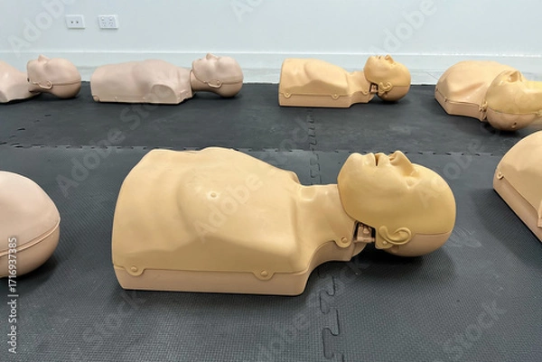 Fototapeta CPR training mannequins on a black mat in a classroom setting.