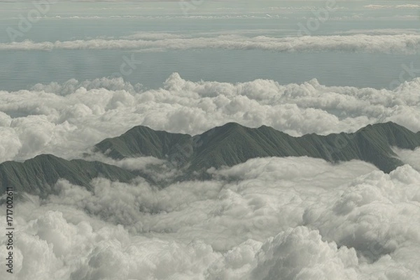Obraz Lush green mountain range peaks emerging from a sea of white clouds