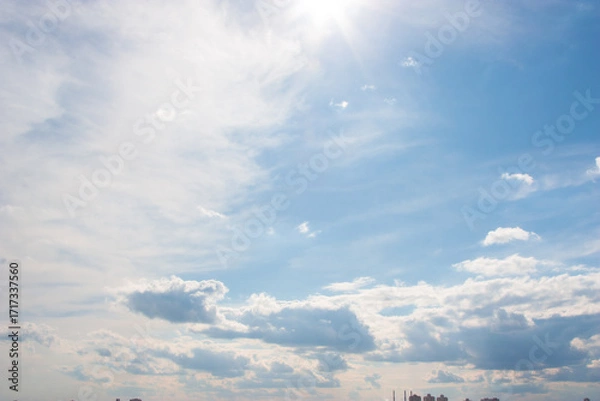 Fototapeta Blue sky background with clouds. High clear bright blue sky over the city with fluffy clouds on a sunny day